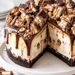 This candy bar cheesecake cake stacks chocolate cake, cheesecake, caramel & candy bars into one ah-mazing, over-the-top dessert!