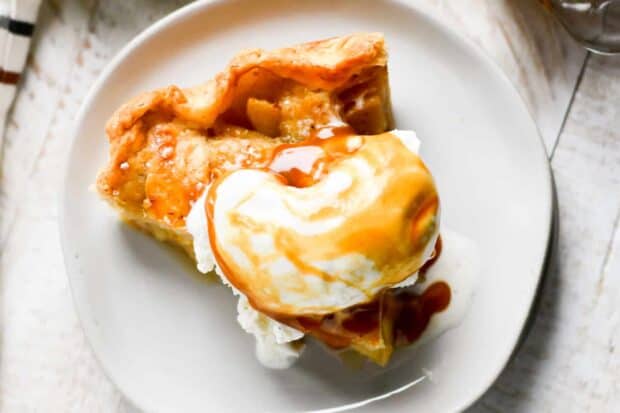 Slice of yummy apple pie with vanilla ice cream on top